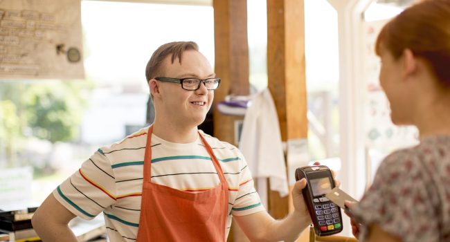 A woman makes a purchase in a farm cafe via contactless payment.